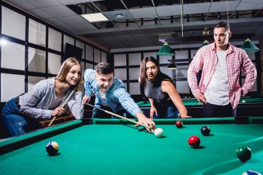 Bilardo oynayan bir grup neşeli genç arkadaş. İşten sonra eğlenceli zamanlar.