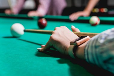 Genç adam bilardoda topa vurmaya çalışıyor. Havuz arkaplanı