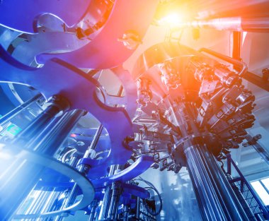 Otomatik doldurma makinesi plastik şişelere su dolduruyor, endüstriyel arka plan