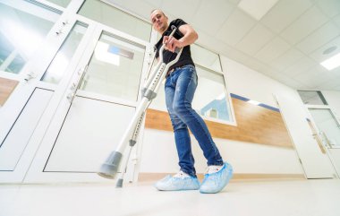 koltuk değneği ile ağaç arka plan Asian genç adam