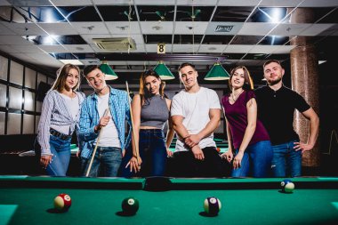 Bilardo oynayan bir grup neşeli genç arkadaş. İşten sonra eğlenceli zamanlar.