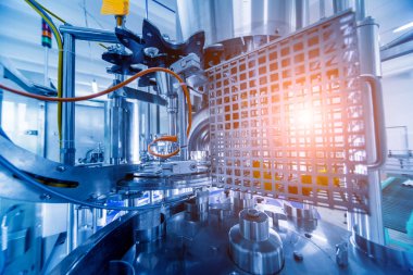 Otomatik doldurma makinesi plastik şişelere su dolduruyor, endüstriyel arka plan