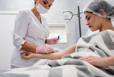 Doktor kozmetik uzmanı kozmetoloji düşürücü prosedürü uyguluyor. Enfüzyon. Güzellik salonunda genç bir kadın. Kozmetoloji kavramı.