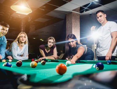 Bilardo oynayan bir grup neşeli genç arkadaş. İşten sonra eğlenceli zamanlar.