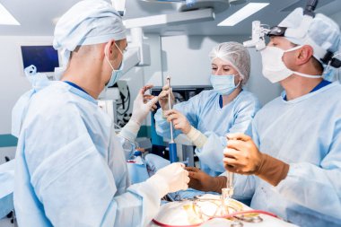 Omurilik ameliyatı. Ameliyathanede ameliyathanede ameliyat aleti olan bir grup cerrah. Laminektomi. Modern tıbbi arka plan