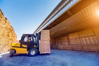 Forklift yükleyicisi keresteleri kuru fırına yüklüyor. Ağaç kuruyor.