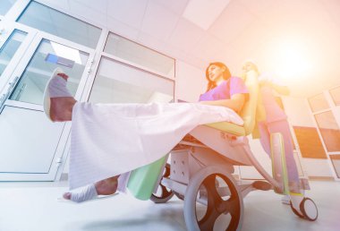 Hemşire hastanedeki hastayla seyyar tıbbi sandalyeyi hareket ettiriyor. Tıbbi ekipman. Kavram