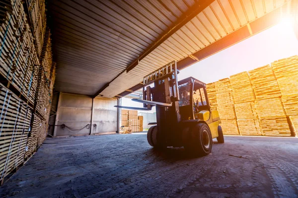 Forklift yükleyicisi keresteleri kuru fırına yüklüyor. Konteynırlarda odun kuruyor. Endüstriyel kavram