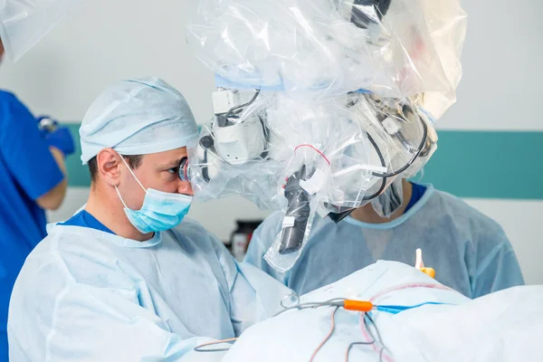 Brain surgery. Group of surgeons in operating room with surgery equipment.