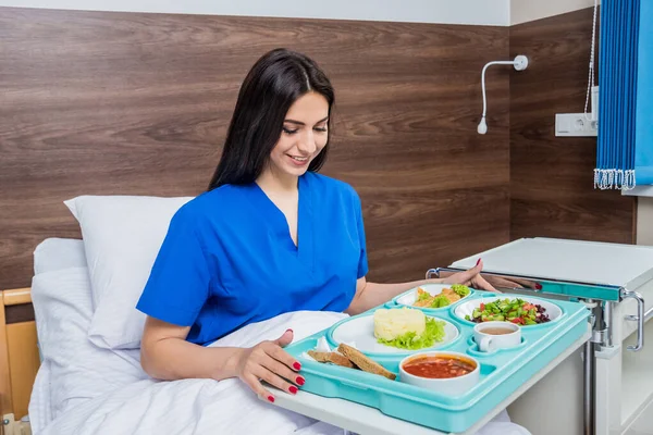 Junge Frau Isst Krankenhaus Tablett Mit Frühstück Für Patientin — Stockfoto