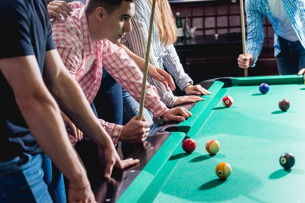 Bilardo oynayan bir grup neşeli genç arkadaş. İşten sonra eğlenceli zamanlar.