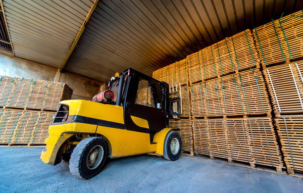 Forklift loader load lumber into a dry kiln. Wood drying in containers