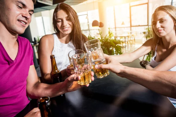 Cheerful friends in the pub. Drinking beer, talking, having fun. Meeting friends after work