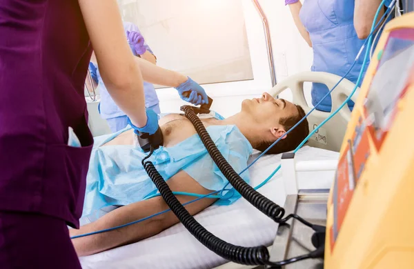 I medici danno rianimazione a un paziente di sesso maschile al pronto soccorso. Massaggio cardiaco — Foto Stock