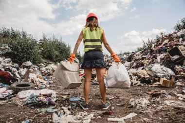 Kadın gönüllü plastik çöpleri temizlemeye yardım ediyor. Dünya günü ve ekoloji kavramı