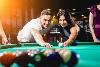 Bilardo oynayan bir grup neşeli genç arkadaş. İşten sonra eğlenceli zamanlar.