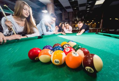 Bilardo oynayan bir grup neşeli genç arkadaş. İşten sonra eğlenceli zamanlar.
