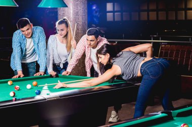 Bilardo oynayan bir grup neşeli genç arkadaş. İşten sonra eğlenceli zamanlar.