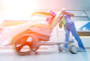 Hemşire hastanedeki hastayla seyyar tıbbi sandalyeyi hareket ettiriyor. Tıbbi ekipman. Kavram