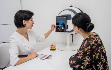 Yüz derisi analiz sistemi. Kozmetik uzmanı kadın yüzünü analiz ediyor. Modern teknolojiler.