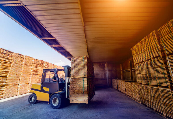 Forklift loader load lumber into a dry kiln. Wood drying in containers