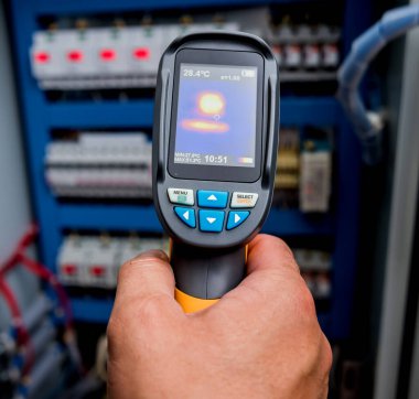 Fünye kutusundaki sıcaklığı kontrol etmek için kızılötesi termal görüntüleme kamerası kullanan teknisyenleri kapat