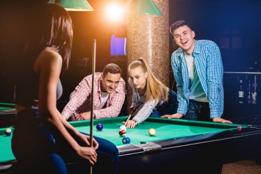Bilardo oynayan bir grup neşeli genç arkadaş. İşten sonra eğlenceli zamanlar.