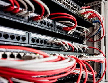 Ağ anahtarı ve ethernet kabloları kırmızı ve beyaz renklerde
