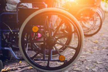 Kamp alanında arkadaşlarıyla dinlenen engelli bir adam. Çadırların arka planında, ormanda tekerlekli sandalye. Kamp yapmak. Yaz zamanı.