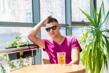 Bardaki genç adam. Bira içmek, pizza yemek. İşten sonra.