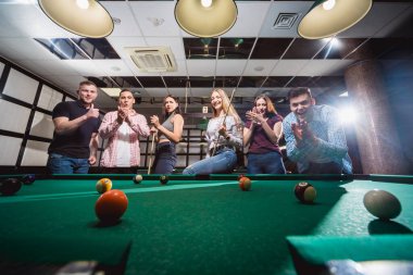 Bilardo oynayan bir grup neşeli genç arkadaş. İşten sonra eğlenceli zamanlar.