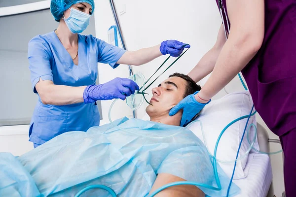 Los médicos dan reanimación a un paciente masculino en la sala de emergencias. Masaje cardíaco —  Fotos de Stock