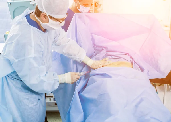 アースコープ手術現代の関節鏡検査ツールと手術室でのチームワークで整形外科医 病院の背景 — ストック写真