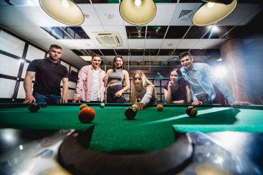 Bilardo oynayan bir grup neşeli genç arkadaş. İşten sonra eğlenceli zamanlar.