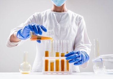 Organik yağ döken bilim adamlarına yakın çekim. Güzellik ve kozmetik bilimleri. Laboratuvar ekipmanları.