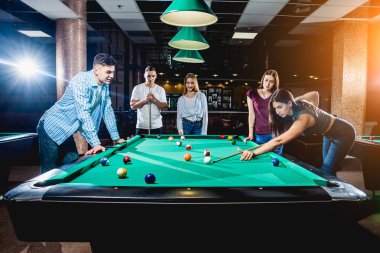 Bilardo oynayan bir grup neşeli genç arkadaş. İşten sonra eğlenceli zamanlar.