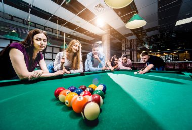 Bilardo oynayan bir grup neşeli genç arkadaş. İşten sonra eğlenceli zamanlar.