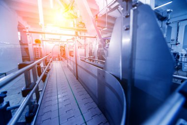 Otomatik doldurma makinesi plastik şişelere su dolduruyor, endüstriyel arka plan