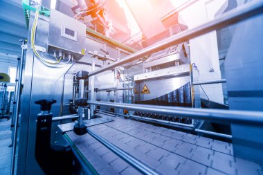 Otomatik doldurma makinesi plastik şişelere su dolduruyor, endüstriyel arka plan