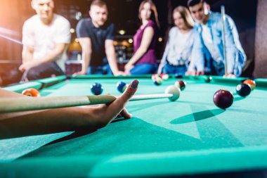 Bilardo oynayan bir grup neşeli genç arkadaş. İşten sonra eğlenceli zamanlar.