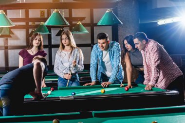 Bilardo oynayan bir grup neşeli genç arkadaş. İşten sonra eğlenceli zamanlar.