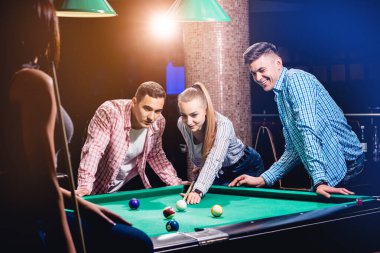 Bilardo oynayan bir grup neşeli genç arkadaş. İşten sonra eğlenceli zamanlar.