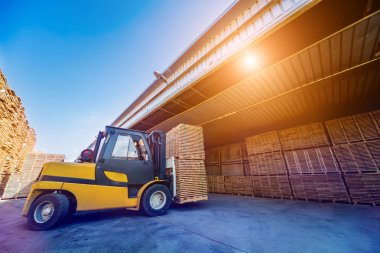 Forklift yükleyicisi keresteleri kuru fırına yüklüyor. Konteynırlarda odun kuruyor.