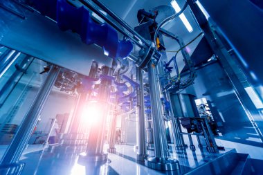 Otomatik doldurma makinesi plastik şişelere su dolduruyor, endüstriyel arka plan