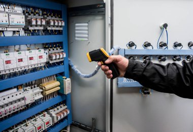 Fünye kutusundaki sıcaklığı kontrol etmek için kızılötesi termal görüntüleme kamerası kullanan teknisyenleri kapat