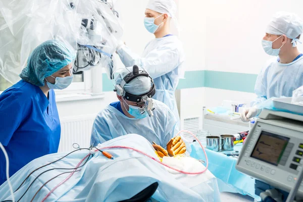 Cirugía cerebral. Grupo de cirujanos en quirófano con equipo quirúrgico . —  Fotos de Stock