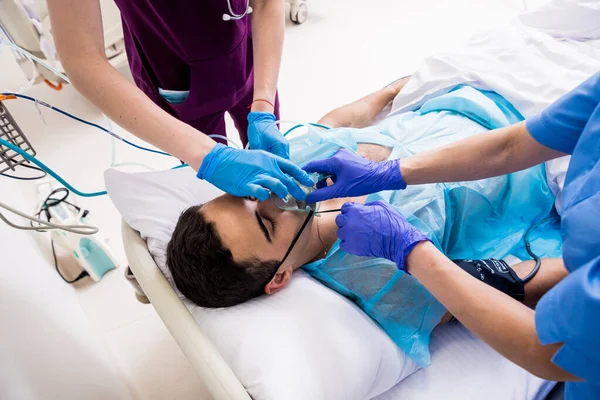 Doctors give resuscitation to a male patient in the emergency room. Cardiac massage