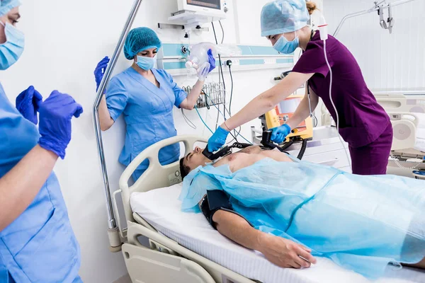 Lékaři dávají resuscitaci mužskému pacientovi na pohotovosti. Srdeční masáž — Stock fotografie