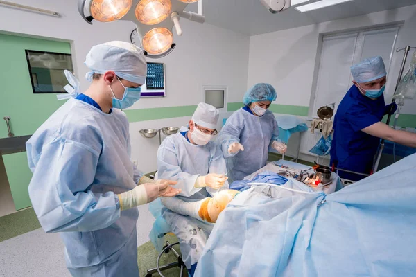 수술이요 수술실에서 현대적 절단기를 사용하는 정형외과 의사들이 일하고 수술이요 병원의 — 스톡 사진