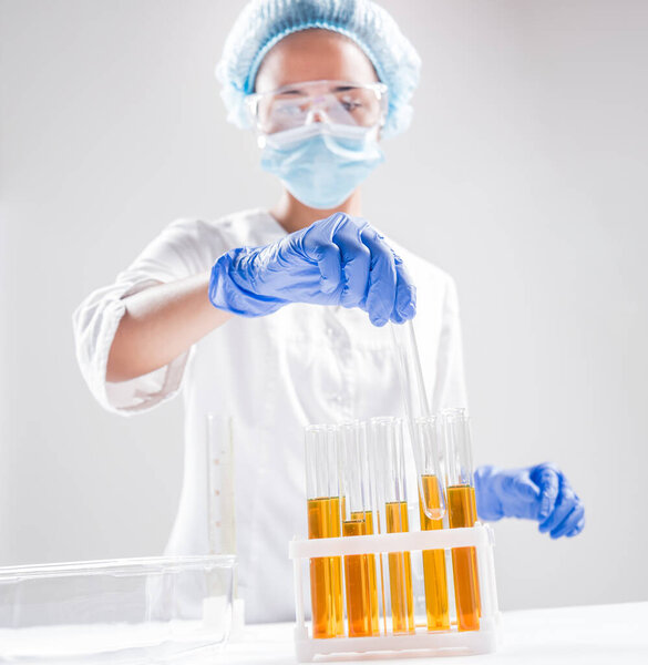 Женщина-ученый разливает органическое масло. Науки о красоте и косметике. Лабораторное оборудование
.